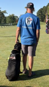 Un asistente con un perro de servicio en el torneo de golf benéfico militar